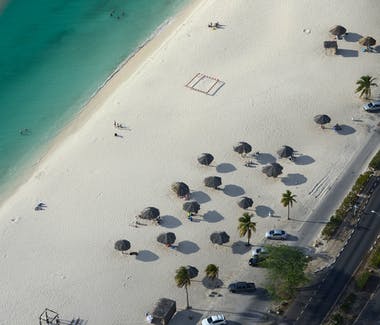 Aerial view of beach with umbrellas.